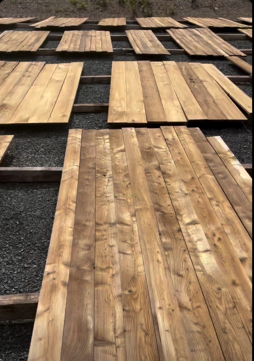 Weatherwood planks laid out to age naturally in the sun